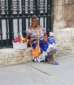 Havana - Cuba op zijn best: kleurrijke Cubaanse dame, zorgenloos en ontspannen met sigaar.