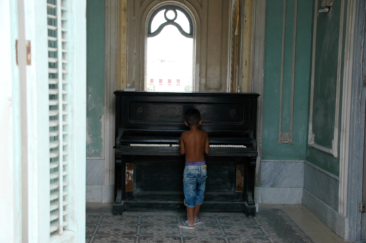 Cuba - Een lief jongetje achter de piano in een oud pand